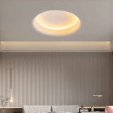 "A close-up view of the textured surface of a round, recessed light, illuminated with a warm glow."