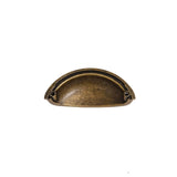 "A vintage brass cup-shaped drawer pull with a smooth, rounded design and a subtle black undertone, made of durable metal."