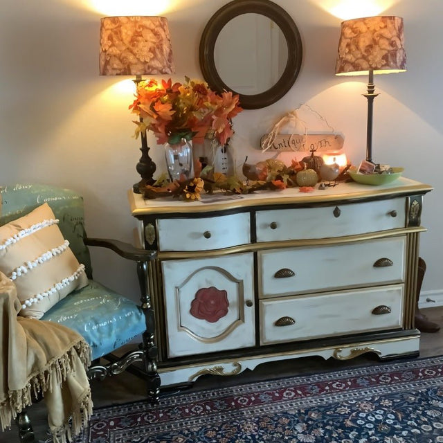 "Vintage brass fan-shaped drawer pulls with detailed ridges, installed on a painted dresser in a traditionally decorated room with lamps and a round mirror."