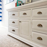 "Vintage brass fan-shaped drawer pulls with detailed ridges, installed on a white dresser with multiple drawers, enhancing its traditional style."