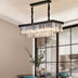 Black metal rectangular chandelier with layered crystal glass prisms suspended above a dining table.