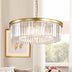 Brass drum chandelier with clear glass rods hanging in a bright bedroom above pink flowers and a window.