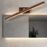 "A modern copper and walnut wall lamp with a linear design, angled to showcase its sleek profile, mounted above a rectangular mirror in a contemporary bathroom with a minimalist aesthetic."