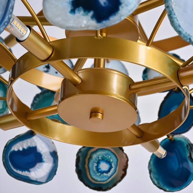 "Close-up of a gold metal Zylan chandelier showing the frame, light bulbs, and blue agate slices."