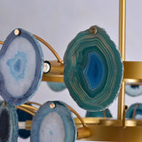 "Close-up of a blue agate slice on a gold metal Zylan chandelier, showing the stone's texture and detail."