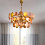 "Gold metal Zylan chandelier with layered circular design and warm-toned agate slices, hanging in a room with sheer curtains."