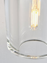 "Close-up detail of a clear glass shade, showing its shape and the illuminated bulb inside."