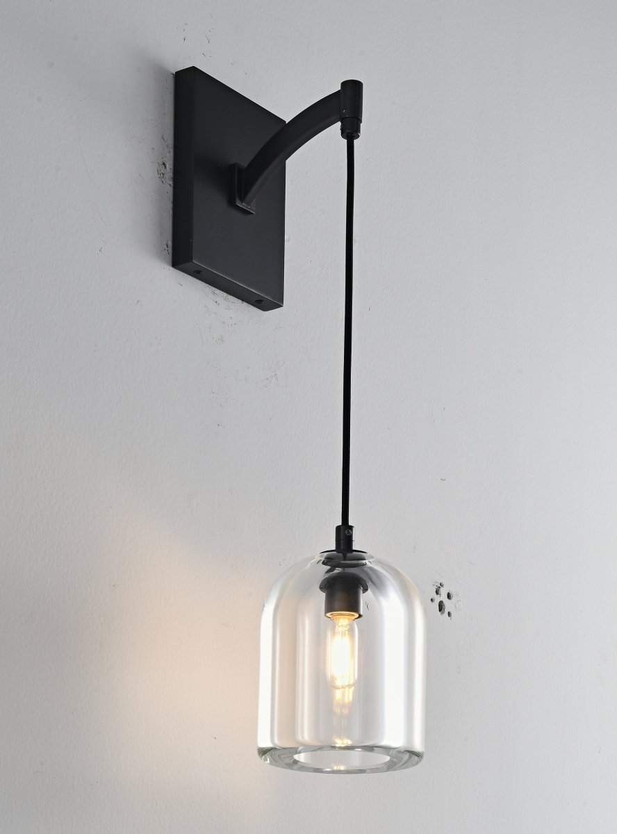 "A modern black wall lamp with a dome-shaped clear glass shade, blending elegance and minimalist design with a curved arm and rectangular base."