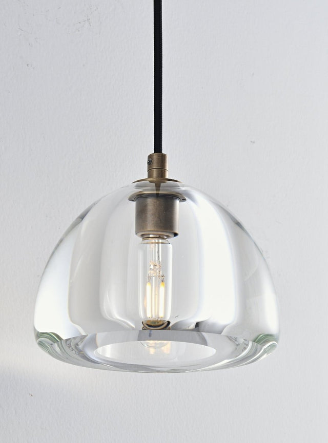 "A modern wall lamp with a clear glass shade, featuring a visible bulb and a black cord."