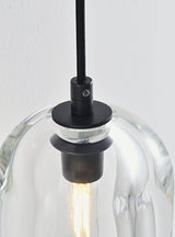 "Close-up detail of a modern wall lamp with a clear glass shade, showing the black fixture and a warm, illuminated bulb."