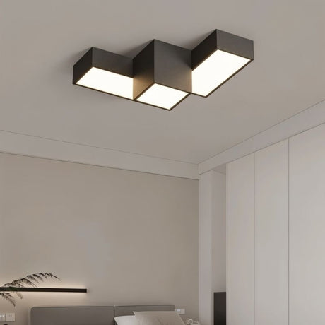"A geometric LED ceiling light with interlocking rectangular forms, providing diffused illumination in a modern bedroom setting."