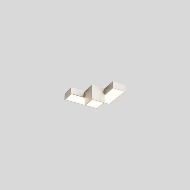 "A white geometric ceiling light with interlocking rectangular forms, isolated against a neutral background, showcasing its modern design."