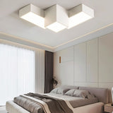 "A white geometric ceiling light with interlocking rectangular forms, illuminating a modern bedroom with diffused light."