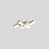 "A white multi-piece geometric ceiling light with interlocking rectangular forms, isolated against a neutral background, showcasing its modern design."