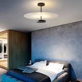 "A minimalist ceiling light with a circular acrylic diffuser and a sleek metal frame illuminating a modern bedroom."