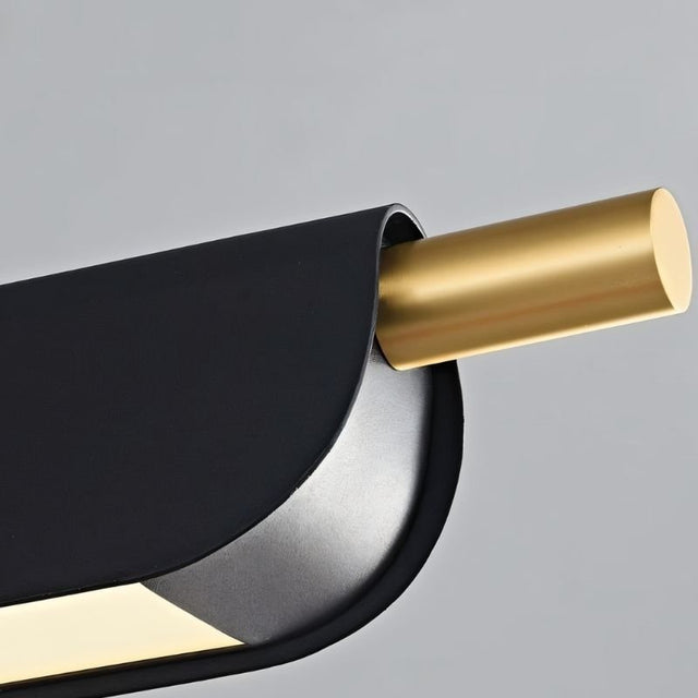 "Close-up of a modern pendant light showing a black metal frame and a gold cylindrical accent."