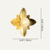Gold petal wall lamp with cream center sphere against neutral background.