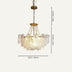 Brass and clear glass chandelier with draped strands, hanging against a neutral background.