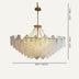 Crystal glass chandelier with brass finish and chain suspension against a neutral background.