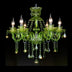 Green crystal chandelier with eight lit candle-style arms against a black background.