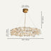 Gold branch chandelier with crystal accents suspended from brass canopy against white background.