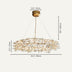 Brass pendant chandelier with organic branch-like crystal design suspended from ceiling against neutral background.