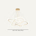 Modern pendant chandelier with gold metal rings and white acrylic accents on cream background.