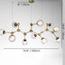 Modern brass chandelier with frosted glass globe shades suspended from ceiling against white background.