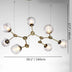 Modern brass chandelier with eight textured glass globe shades suspended against a white background.