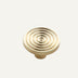 Brass cabinet knob with concentric circular design on white background.