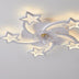 White acrylic ceiling light fixture with star and moon shapes and integrated fan, illuminated against a white background.