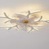 Modern white LED ceiling light fixture with branching arms and warm illumination against a neutral ceiling.