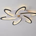 Modern ceiling light fixture with six curved black and white LED arms mounted on white ceiling.
