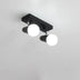 Two-light ceiling fixture with black metal base and adjustable white globe shades mounted on white wall.