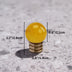 Yellow crystal ball knob with brass base shown with measurement dimensions on textured gray surface.