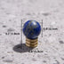 Blue lapis lazuli sphere with brass stand displayed on a concrete surface with dimension measurements.