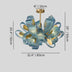 Blue textured glass petal chandelier with brass accents and canopy on gray background.
