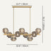 Brass linear chandelier with five crystal globe lights and ornate brass details, shown against white background.